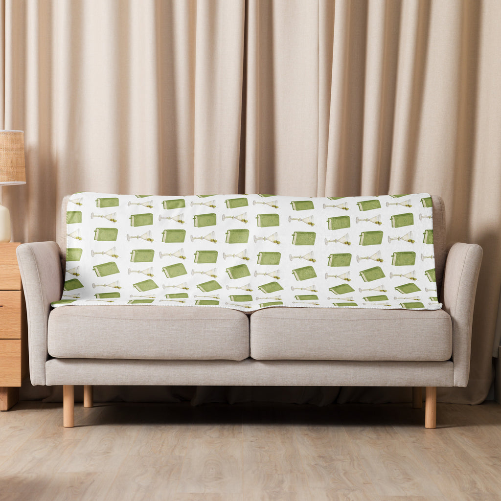  37x50 " sherpa lined blanket with dirty martinis and green books on it , product mock-up image laying over couch