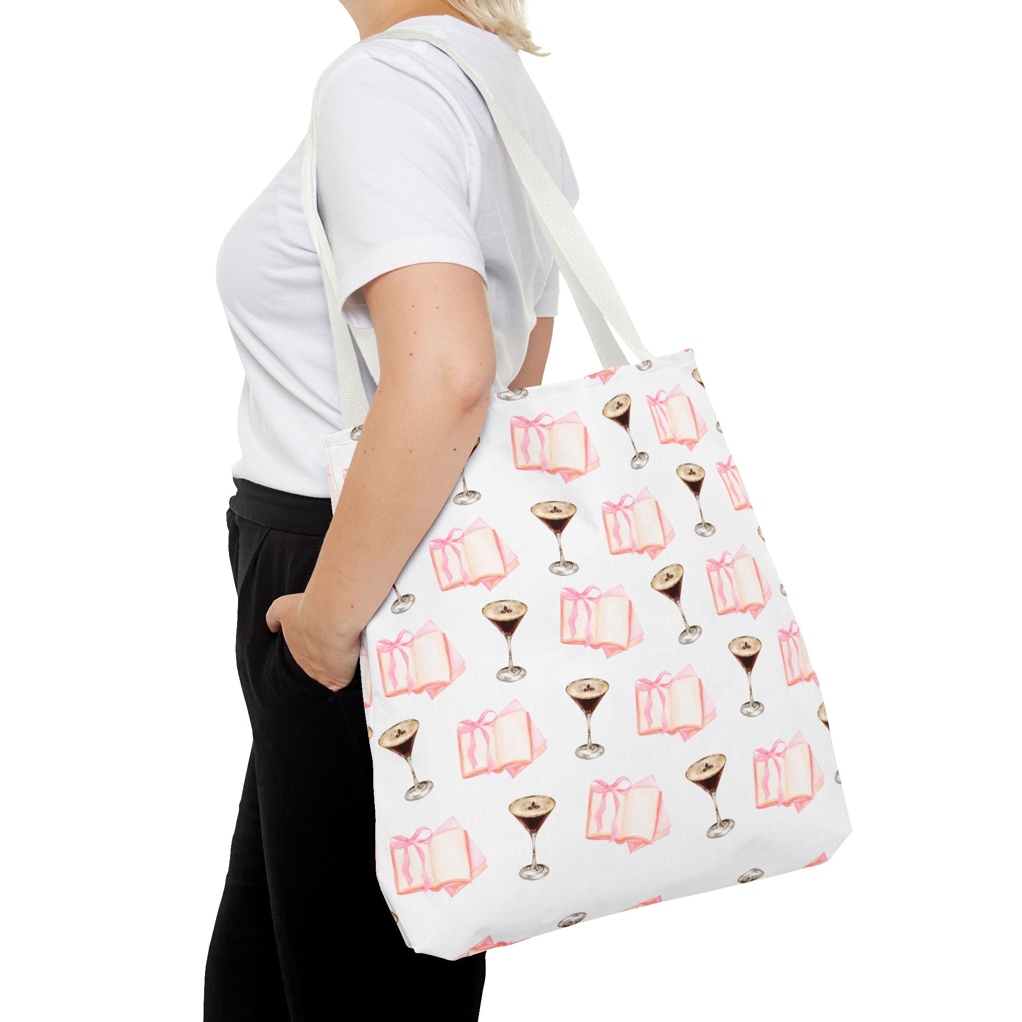 Person holding a tote bag with book and glass pattern on a white background