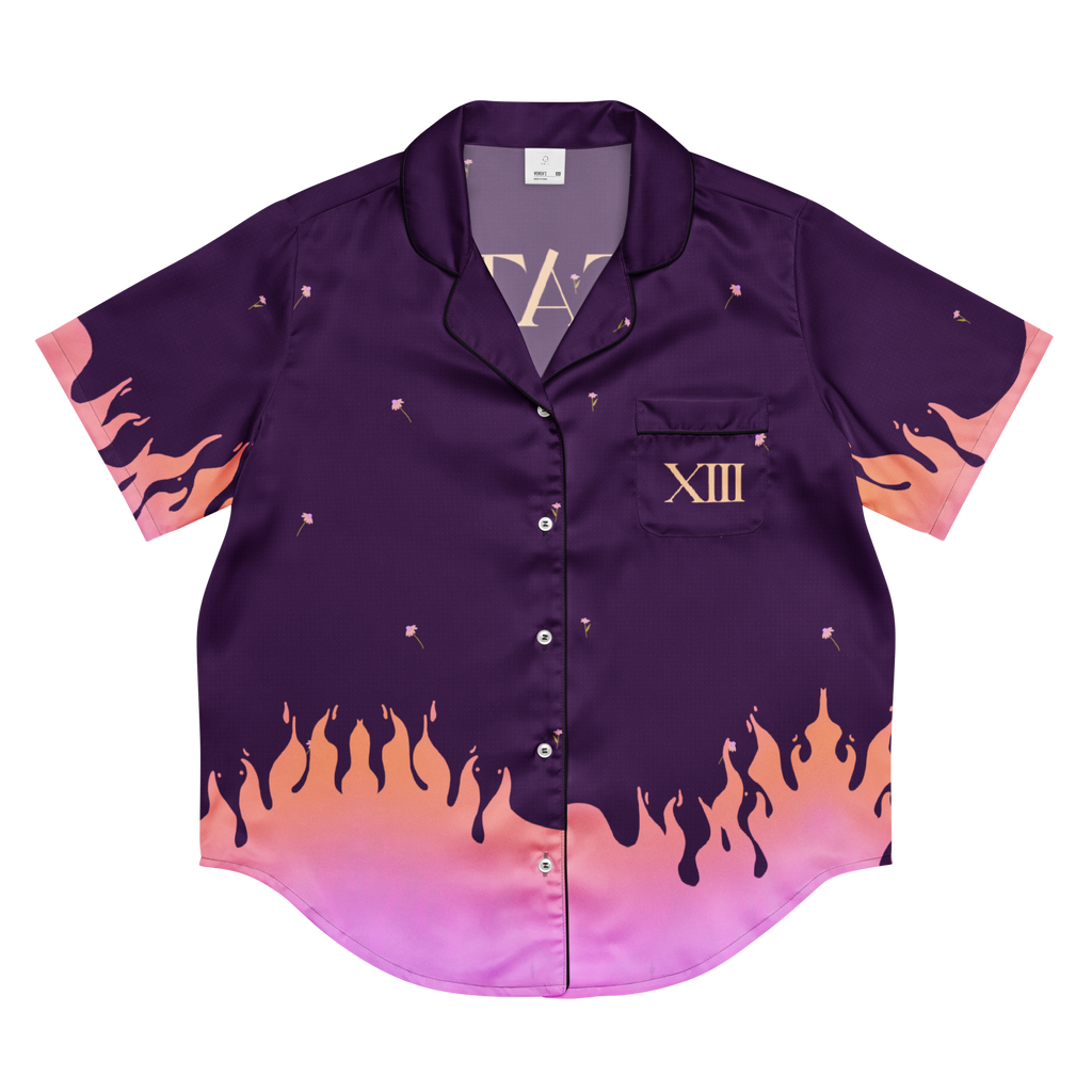 A short-sleeve button-up pajama shirt in deep purple with a pink and orange flame gradient design along the bottom hem and sleeve cuffs, featuring a chest pocket with the Roman numeral XIII.