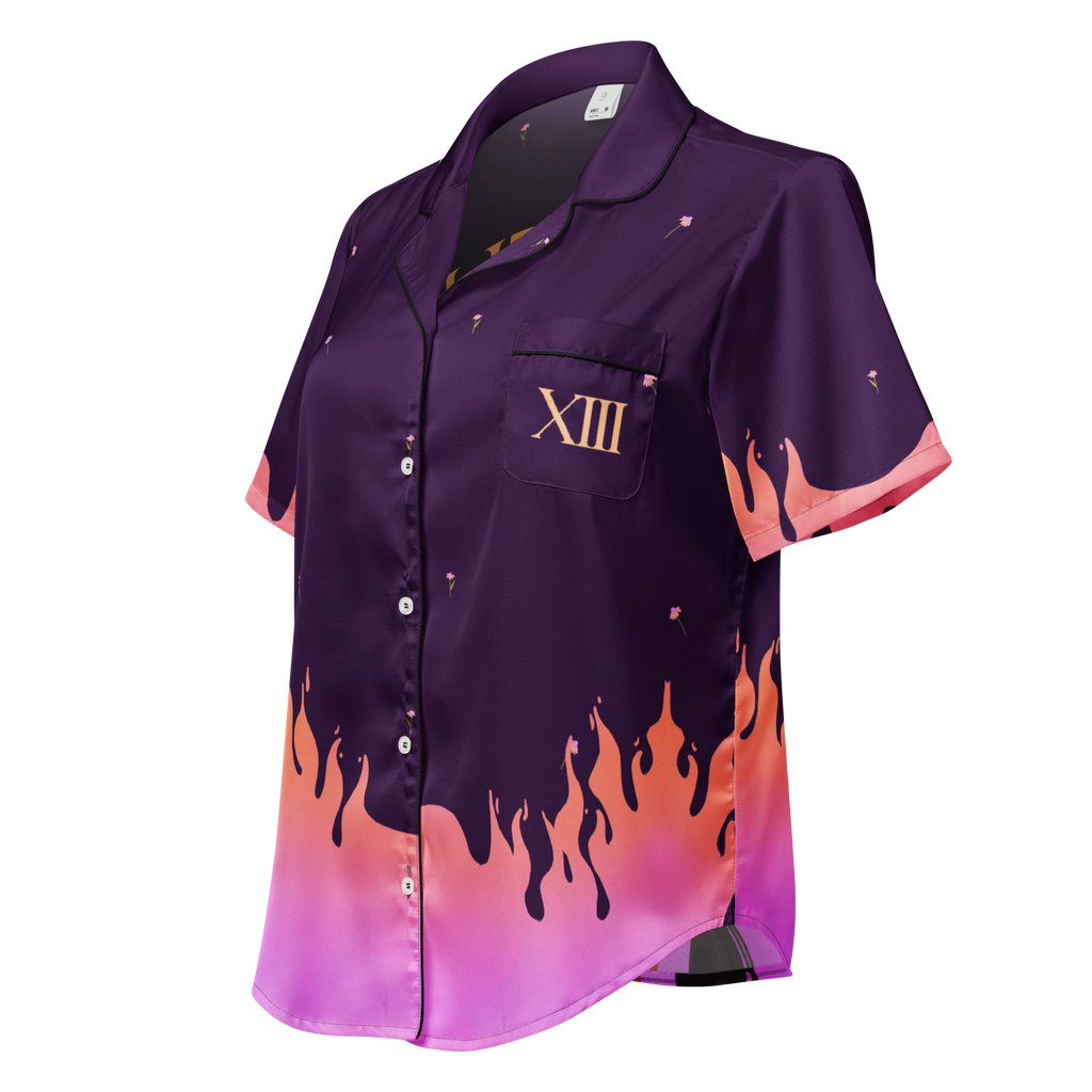A short-sleeve button-up pajama shirt in deep purple with a dripping flame pattern in pink, orange, and black, featuring a chest pocket with 'XIII' printed in gold.