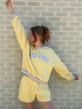 Person wearing a yellow tracksuit with text on a tiled floor
