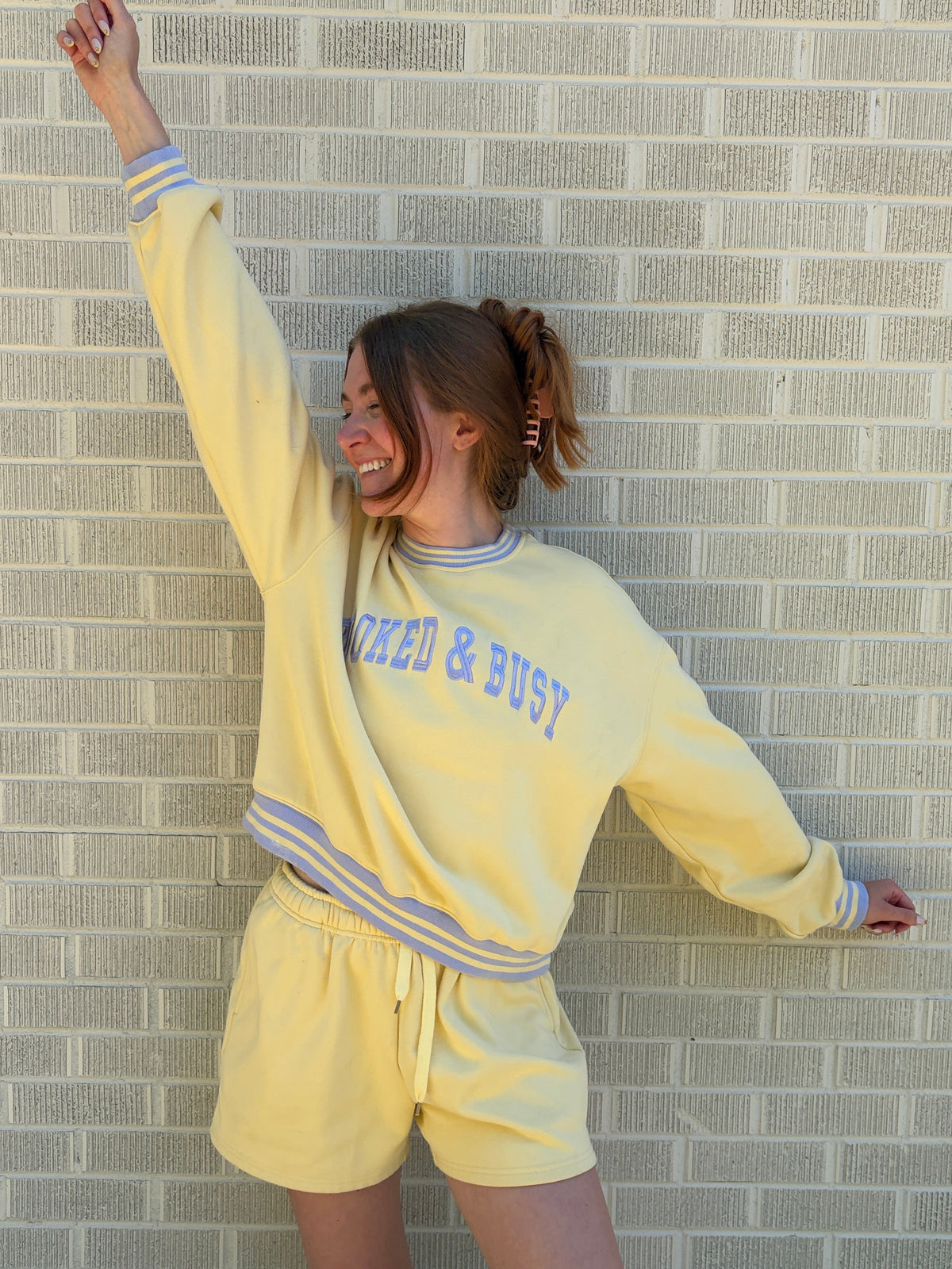 Person wearing a yellow tracksuit with text on a tiled floor