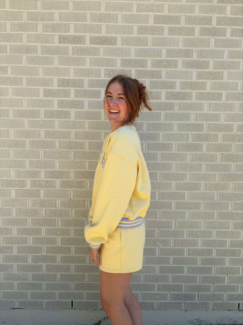 Person wearing a yellow outfit standing on a tiled floor