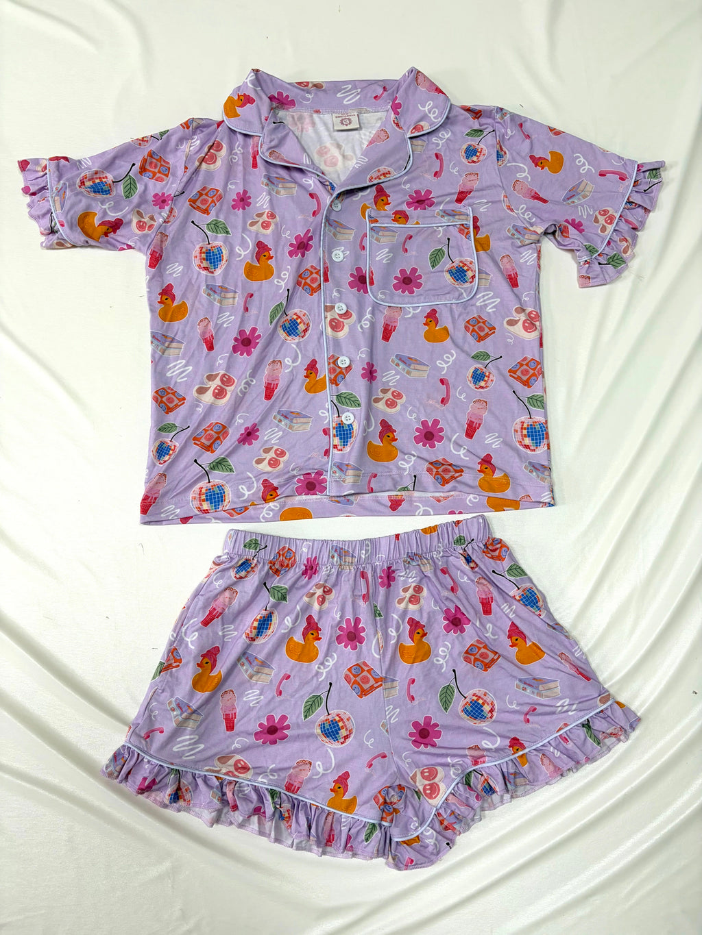 Children's pajama set with floral and duck pattern on a white background