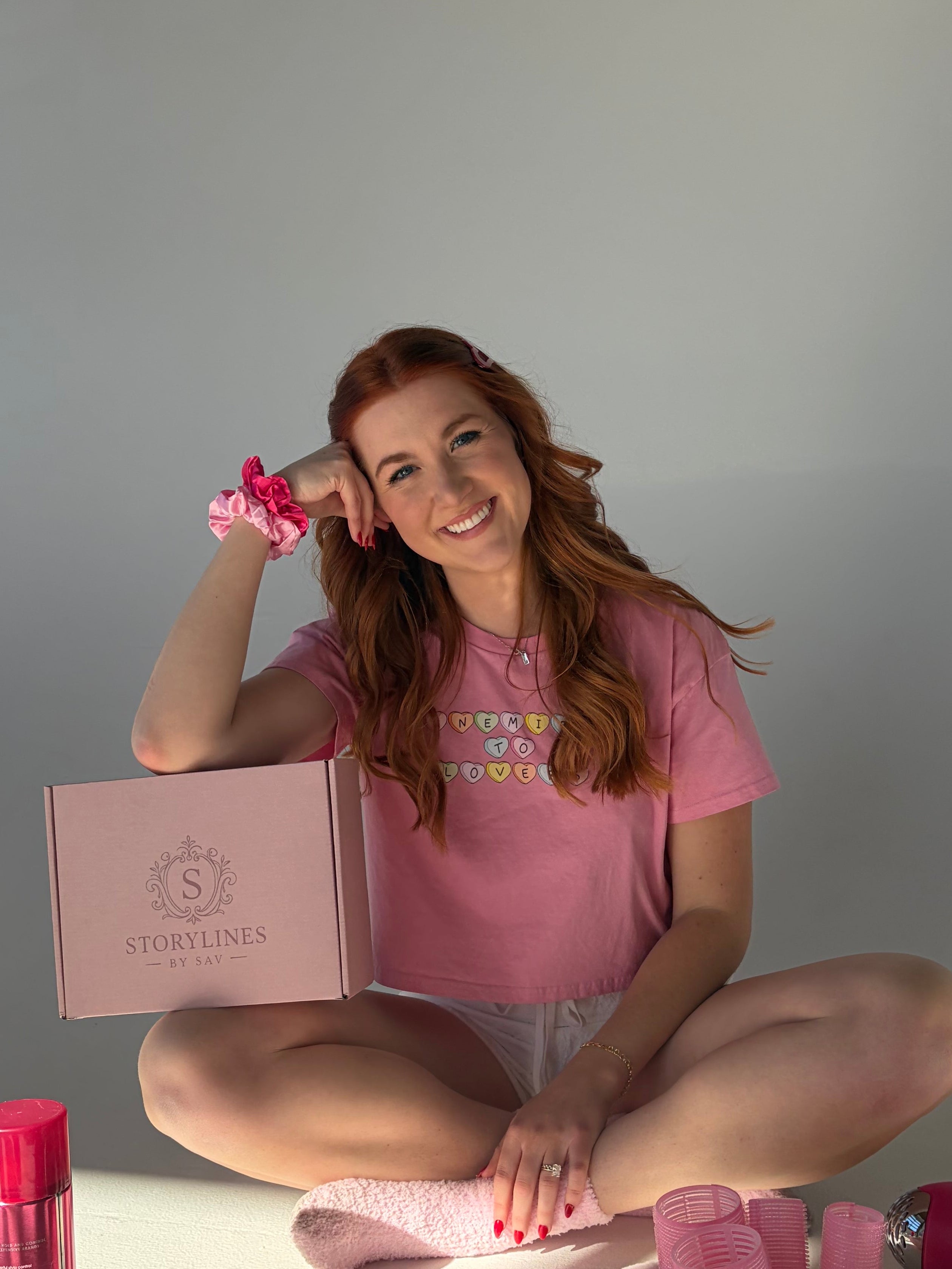 Woman in pink outfit with products on a white floor