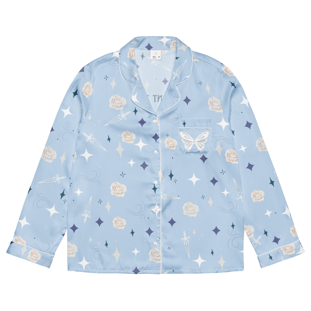 A light blue long-sleeve pajama shirt with a white, navy, and beige celestial print featuring stars, moons, roses, and a butterfly, shown flat on a white background.
