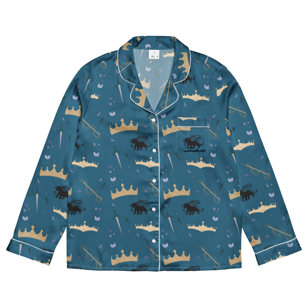A long-sleeve pajama shirt with a teal blue base, featuring an all-over print of gold and beige crowns, black lions, and small light blue birds. It has white piping along the collar, cuffs, and front placket, and is displayed flat against a solid white background.