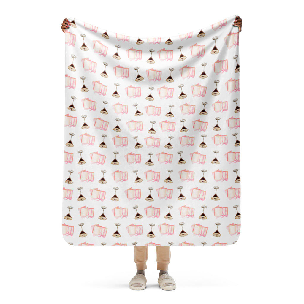woman holding up 50x 60" Sherpa lined blanket with espresso martinis and pink books product mock-up 