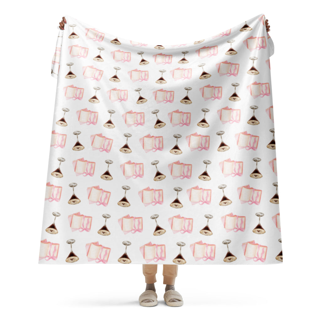 woman holding up 60x80 " Sherpa lined blanket with espresso martinis and pink books product mock-up 