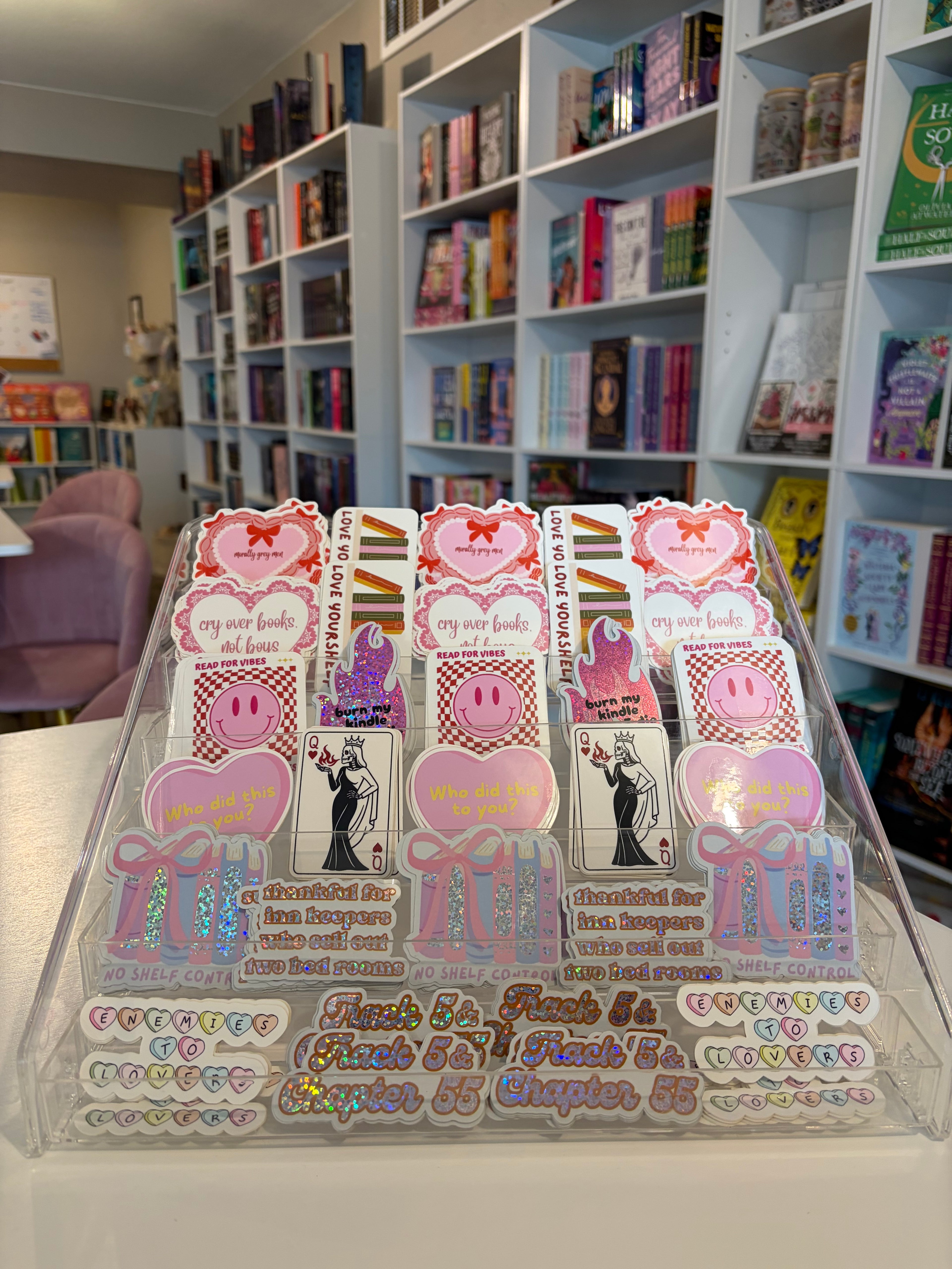 Sheet of decorative stickers with text and graphics on a surface with a bookshelf in the background.