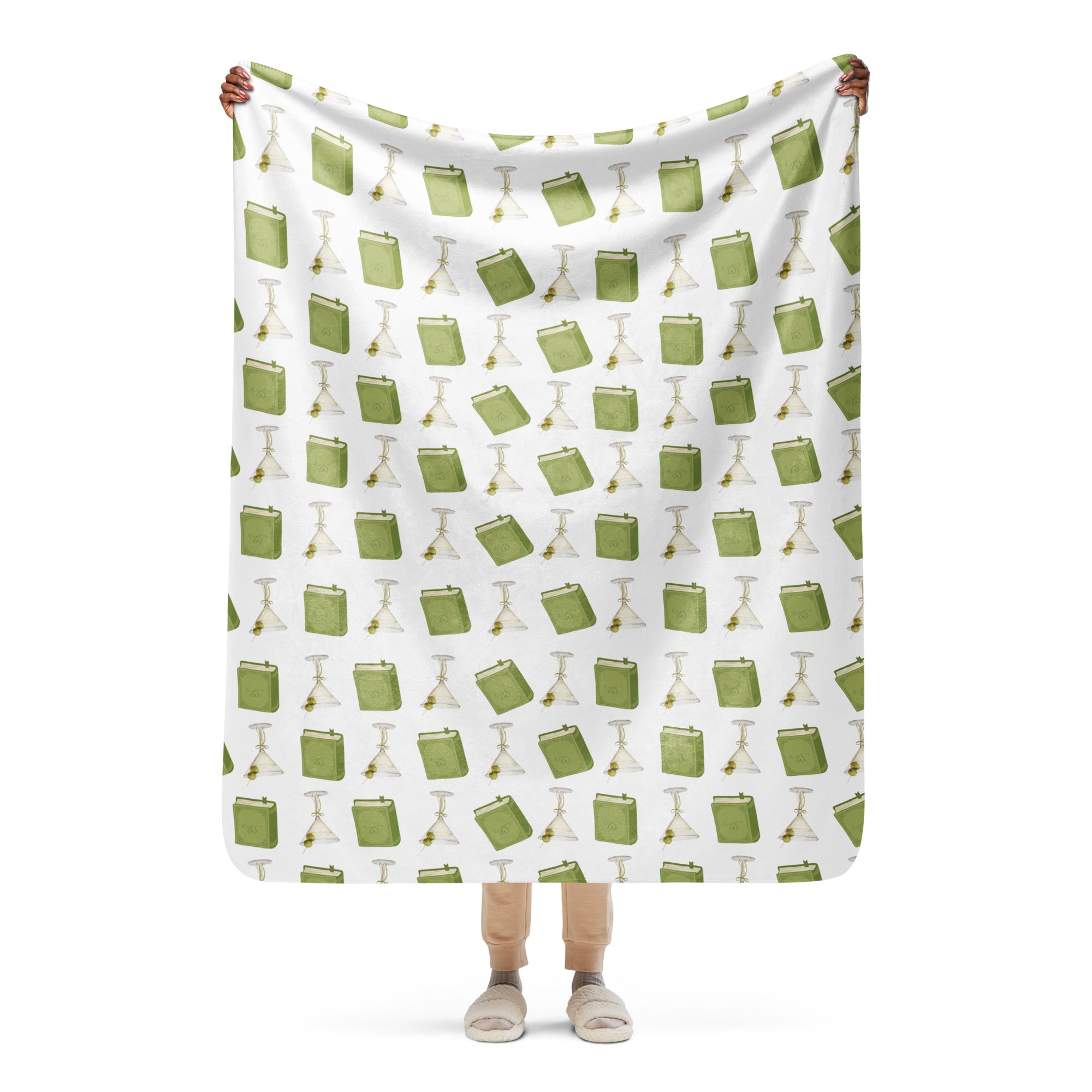 woman holding 50x60" sherpa lined blanket with dirty martinis and green books on it , product mock-up image